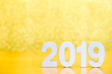 Ahşap masa ve altın bokeh arka plan üzerinde mutlu yeni yıl için sayı 2019