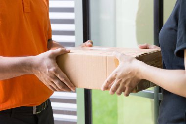 Woman customer accept and receive parcel from delivery man at front home clipart