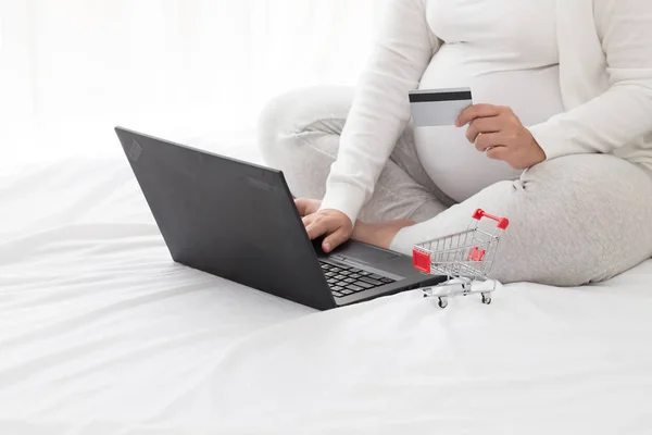 Pregnant women seeking maternity clothes and new mom product by shopping online web application and using credit card to pay