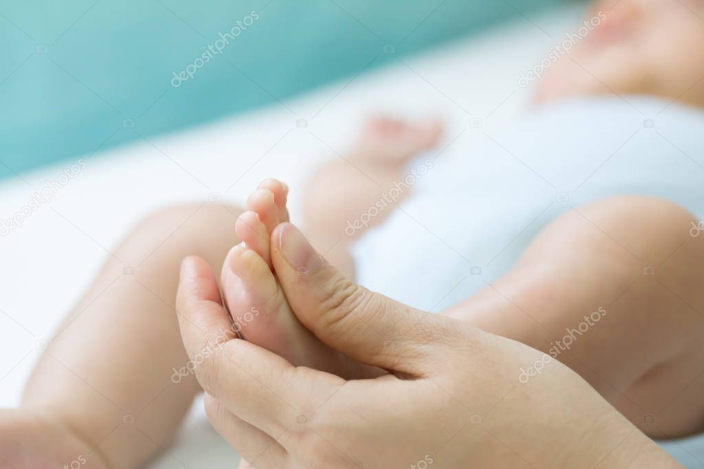 Reflexotherapy of the feet of a newborn baby, Massage foot of the child concept