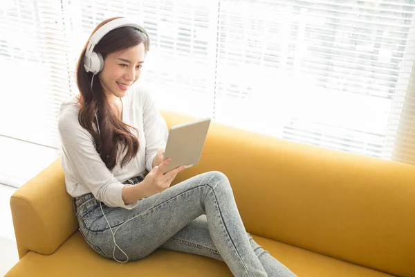 Hermosa Mujer Asiática Joven Escuchando Música Con Auriculares Utilizando Una —  Fotos de Stock