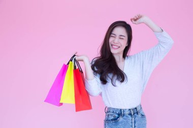Happy beautiful Asian women enjoy shopping on pink background, Shopaholic, Buy during promotion or special offer price in Valentines day, Consumerism women lifestyle and female model concept clipart