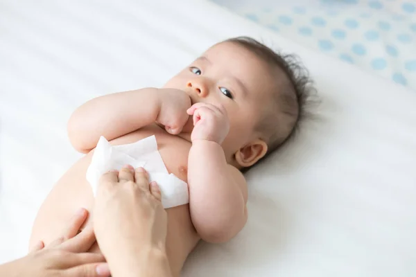 おむつやおむつを変更し 手や顔や足を拭くときにお母さんのクリーニングとウェットティッシュで体の赤ちゃんを拭く ぬれたワイプ紙の概念とお母さんと幼児の子供のための個人衛生 — ストック写真
