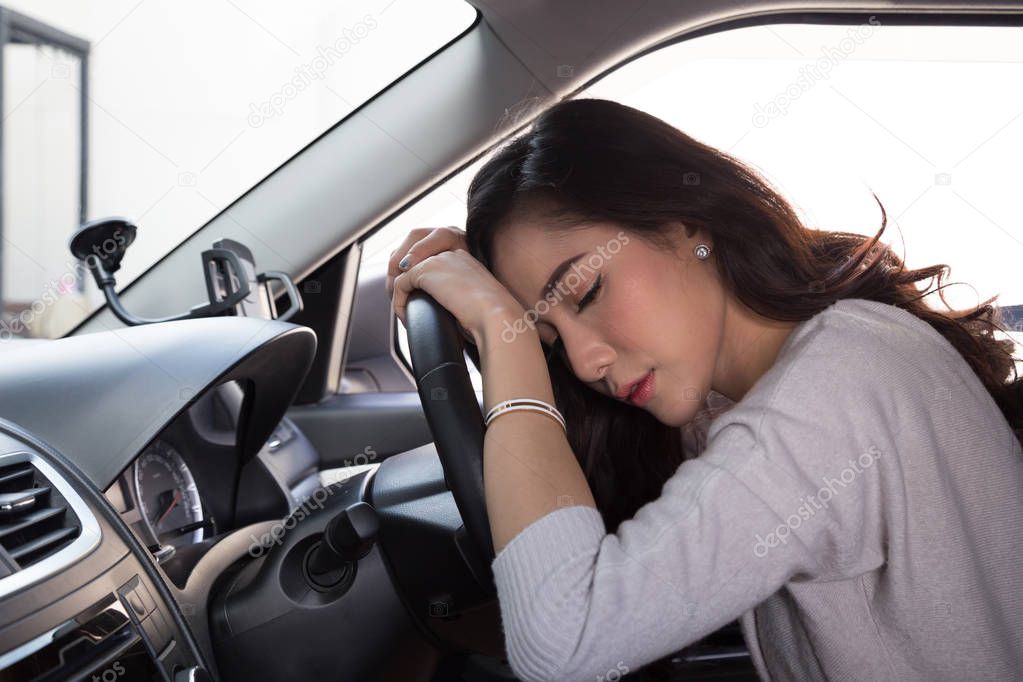 Tired young woman sleep in car, Hard work causes poor health, Sit asleep while the car is on a red light, Traffic jam or overworked concept