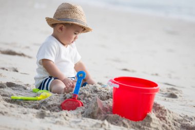 Tropik sahilde kum ile oynayan bebek. Çift fonksiyon becerileri çocuk kavramı