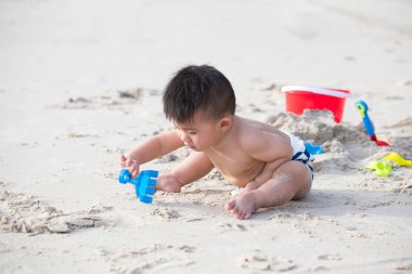 Tropik sahilde kum ile oynayan bebek. Çift fonksiyon becerileri çocuk kavramı