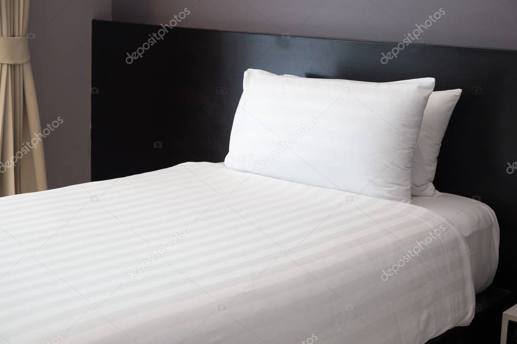 Single white bed in the room at the hotel