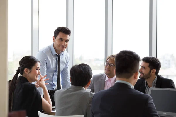 Головний бізнесмен, що стоїть за конференц-столом під час командного засідання, підприємці укладають угоду про початок співпраці на групових переговорах командної роботи — стокове фото
