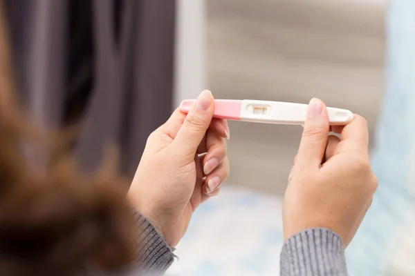 Woman hands holding ovulation test and were trying to get pregnant with collect urine put the test strip and positive results — Stock Photo, Image