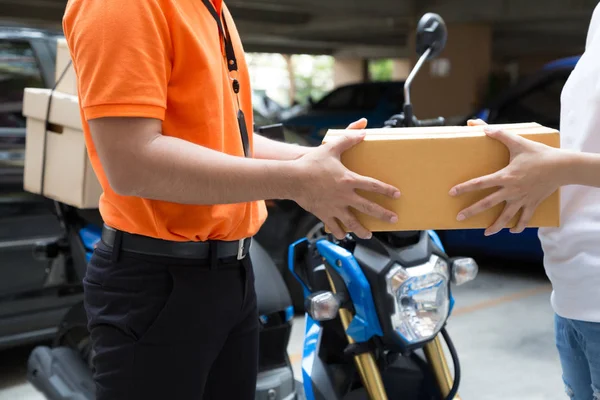 Mujer mano aceptando una entrega de cajas del repartidor, Entregar mercancías por servicio de motocicleta, Transporte rápido y gratuito — Foto de Stock