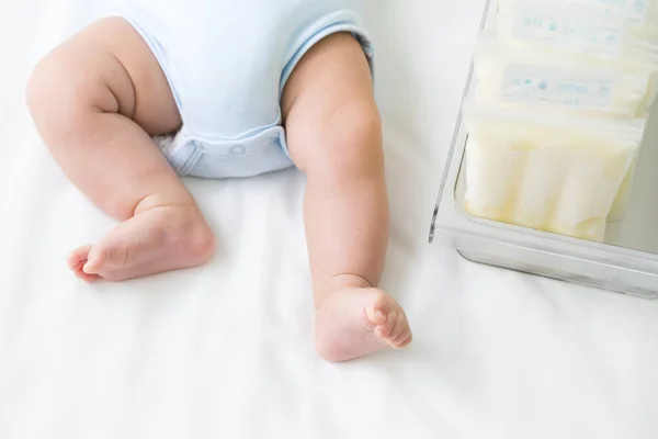 Грудное Молоко Заморожено Мешке Хранения Ноге Младенца Лежит Белой Кровати — стоковое фото