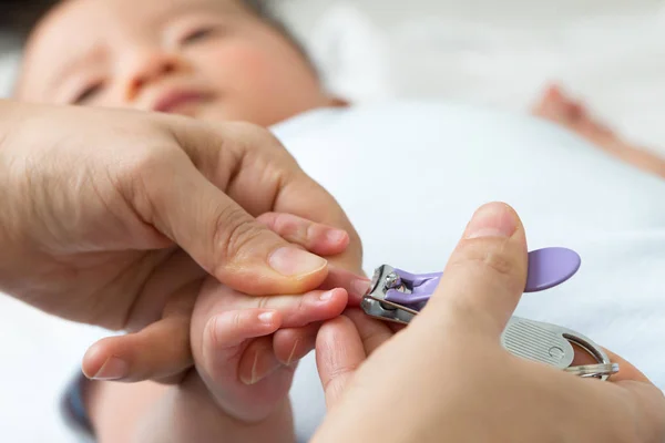 Madre corte uñas bebé usando cortauñas — Foto de Stock