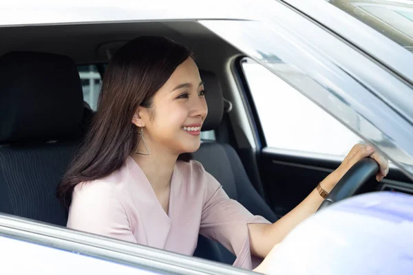 Las mujeres asiáticas que conducen un coche y sonríen felizmente con expresión positiva alegre durante la impulsión al viaje, la gente goza el transporte de la risa y la mujer feliz relajada en concepto de vacaciones del roadtrip — Foto de Stock