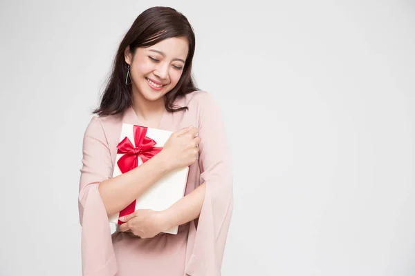 Feliz hermosa mujer asiática sonrisa con caja de regalo roja y espacio de copia de fondo de la sala de estar blanca. Chicas adolescentes enamoradas, recibiendo regalos de amantes. Concepto de Año Nuevo, Navidad y San Valentín —  Fotos de Stock