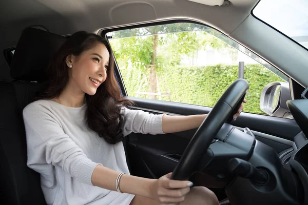 Las mujeres asiáticas que conducen un coche y sonríen felizmente con expresión positiva alegre durante la impulsión al viaje, la gente goza riendo y relajada mujer feliz en concepto de vacaciones del viaje de la carretera, modelo tailandés — Foto de Stock