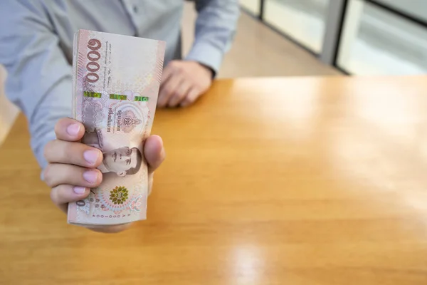 Adam para thai baht tutan, banka kavramından hızlı kredi — Stok fotoğraf