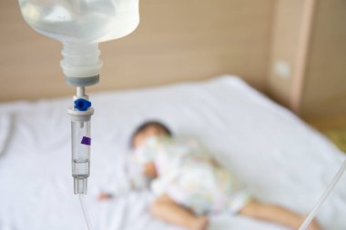 Asyalı erkek bebek hastanede çocuk bölümünde belirlenen infüzyon ile yatakta uyku.