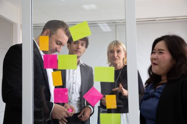 İş adamları Toplantı ekibi, brifing ve yeni plan tartışmak. Ofiste proje üzerinde takım çalışması ile analiz ve fikir paylaşmak için yapışkan notlar kullanın. Beyin fırtınası ve konferans kurumsal konsepti