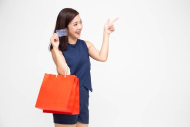 Alışveriş çantaları ve beyaz arka plan üzerinde izole kredi kartı tutan mutlu bir genç kadın Portresi, Shopaholic kavramı için yıl sonu satış veya orta yıl sonu satış promosyon clearence, Asya kadın modeli