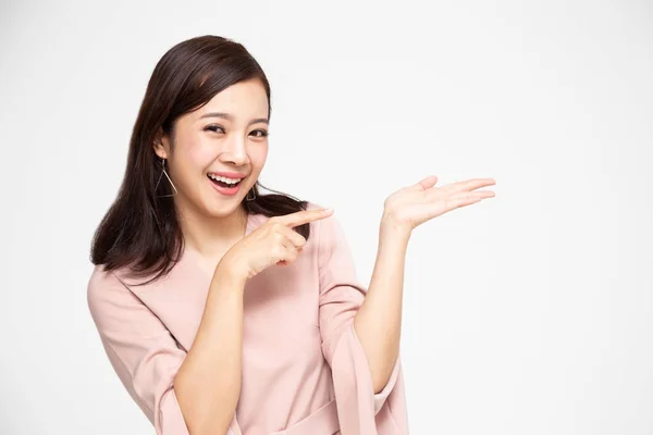 Joven mujer asiática elegante sonriendo y apuntando a espacio de copia vacío aislado sobre fondo blanco —  Fotos de Stock
