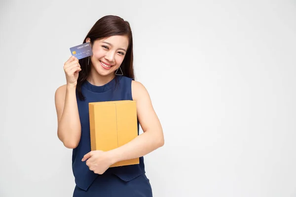 Mujer asiática feliz que sostiene la caja del paquete y la tarjeta de crédito, servicio de envío de entrega y concepto en línea de compras —  Fotos de Stock