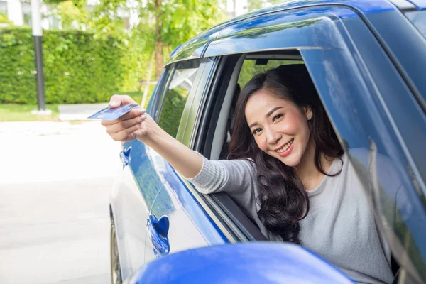 Szczęśliwy młody Asian kobieta trzyma karty płatniczej lub kredytowej karty i używane do płacenia za benzyny, oleju napędowego i innych paliw na stacjach benzynowych, sterownik z floty kart do tankowania samochodów — Zdjęcie stockowe