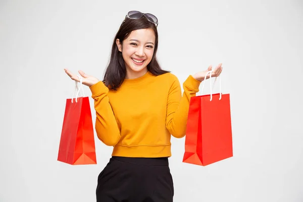 Retrato de una joven feliz sosteniendo bolsas de compras aisladas sobre fondo blanco, venta de fin de año o mediados de año de liquidación de promoción de venta para el concepto Shopaholic, modelo femenino asiático —  Fotos de Stock