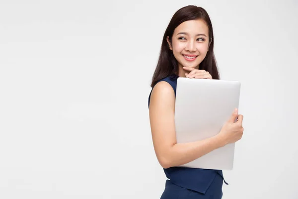 Feliz mujer de negocios asiática sosteniendo ordenador portátil y mirando hacia otro lado sobre fondo blanco —  Fotos de Stock
