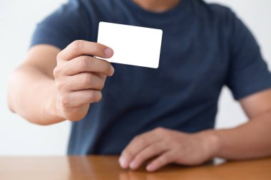 Beyaz kartvizit tutan hevesli genç girişimcinin portresini kapatın