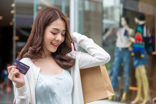 Uśmiechnięta dziewczyna azjatyckich z torby na zakupy i posiadania karty kredytowej — Zdjęcie stockowe