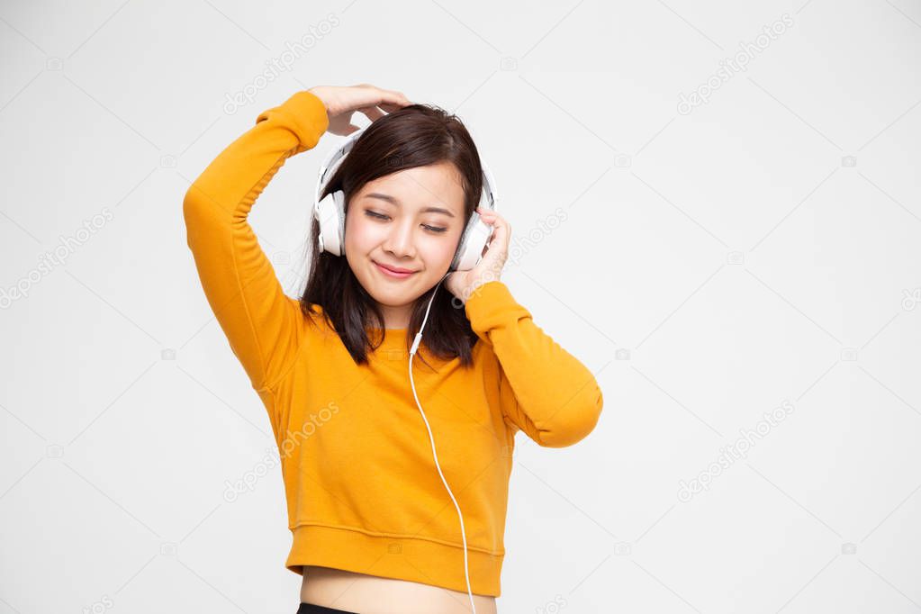 Asian woman listening music with headphones in playlist song application on smartphone