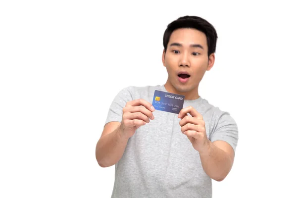 Asiatique homme avec wow visage et montrant carte de crédit à portée de main isolé sur fond blanc — Photo