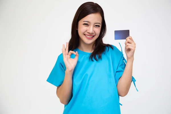 Jeune asiatique belle femme patient montrant carte de soins d'assurance accident personnel et ok signe — Photo