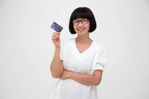 Happy Asian senior woman holding credit card or cash advances, Pay instead of money and especially curated benefits for retirement aged seniors card concept — Fotografia de Stock