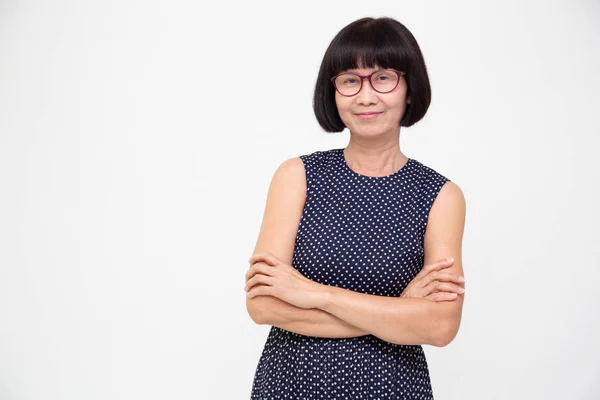 Retrato de mujer mayor asiática con los brazos cruzados aislados sobre fondo blanco, mujer anciana mirando el concepto de cámara —  Fotos de Stock