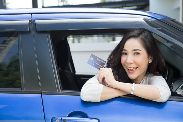 Szczęśliwy młody Asian kobieta Holding karty płatniczej lub karty kredytowej i używane do zapłaty za benzynę — Zdjęcie stockowe