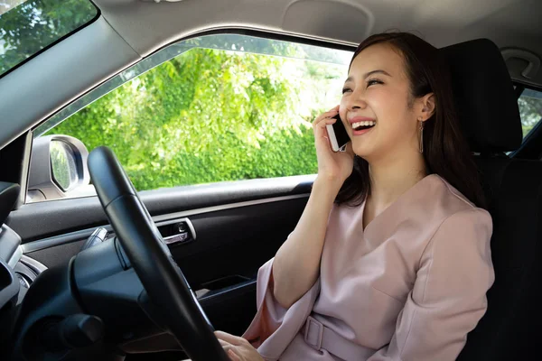 Mujer asiática feliz llamando al servicio de seguros mientras está sentado en el coche — Foto de Stock