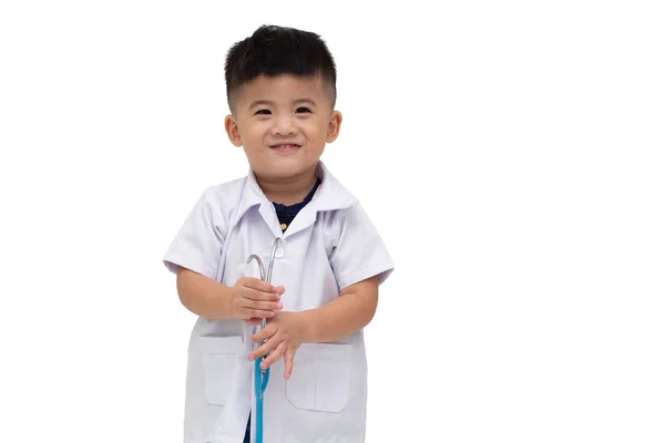 Garotinho sorridente de uniforme médico brincando com estetoscópio — Fotografia de Stock