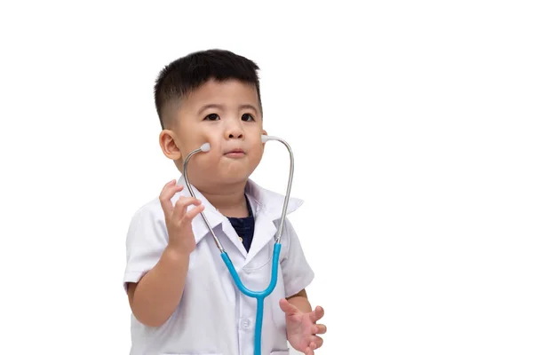 Garotinho sorridente de uniforme médico brincando com estetoscópio — Fotografia de Stock