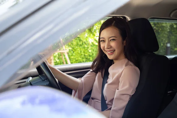 Las mujeres asiáticas felices conduciendo un coche y sonríen con expresión positiva alegre durante la impulsión a la oficina del trabajo en día laborable — Foto de Stock