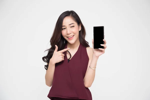Porträtt av vackra asiatiska wowan visar eller presentera mobil telefon ansökan på sidan isolerad över vit bakgrund — Stockfoto