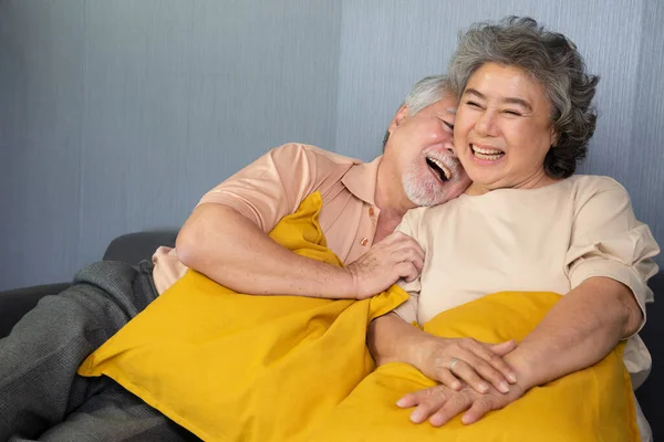 Ασιατικό Ηλικιωμένο Ζευγάρι Γελάει Ενώ Κάθεται Στον Καναπέ Στο Σπίτι — Φωτογραφία Αρχείου