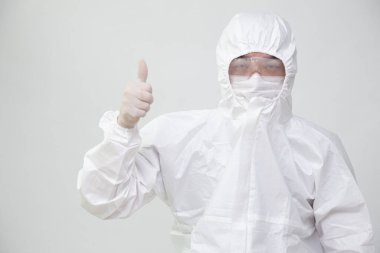 Kişisel Koruyucu Ekipman ya da PPE üniforması giyen Asyalı hemşire ya da doktor kendine güveni ve onayıyla