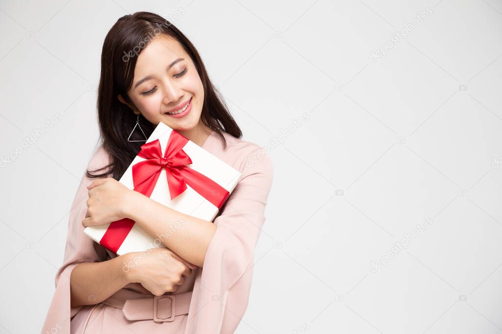 Happy beautiful asian woman smile and hugging gift box isolated on white background. Teenage girls in love, Receiving gifts from lovers. New Year, Christmas and Valentines Day concept