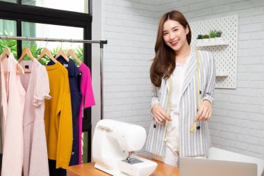 Çalışma odasında dikiş makinesi olan Asyalı güzel, genç moda tasarımcısı kadın, terzi konsepti.