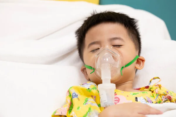Asian little boy making inhalation with nebulizer at hospital, Nebulization concept