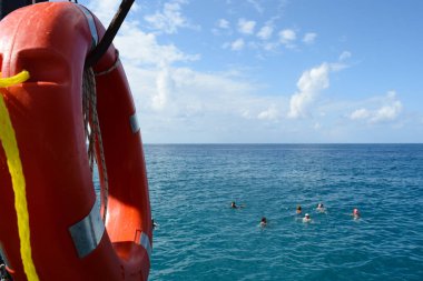 Deniz kıyısı, tatilcilerin için turuncu Lifebuoy