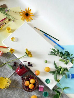 Üstten görünüm, sonbahar, yaz yüklemesinde beyaz bir tuval sanat malzemeleri, taze çiçek ve meyve,