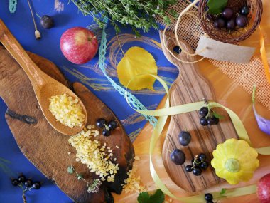 Masada bir sonbahar konulu dekoratif kompozisyon, sebze, baharatlar, deniz ile iki kesme tahtaları pastel boya kalemi ile üstten görünüm boyalı bir mavi ve sarı zemin üzerine tuz