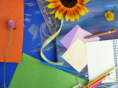 Sanat malzemeleri, Not defteri ve kireçli bir mavi arka plan, sonbahar ve okul, üstten görünüm kavramı üzerinde çiçekler parlak dekoratif bileşimi